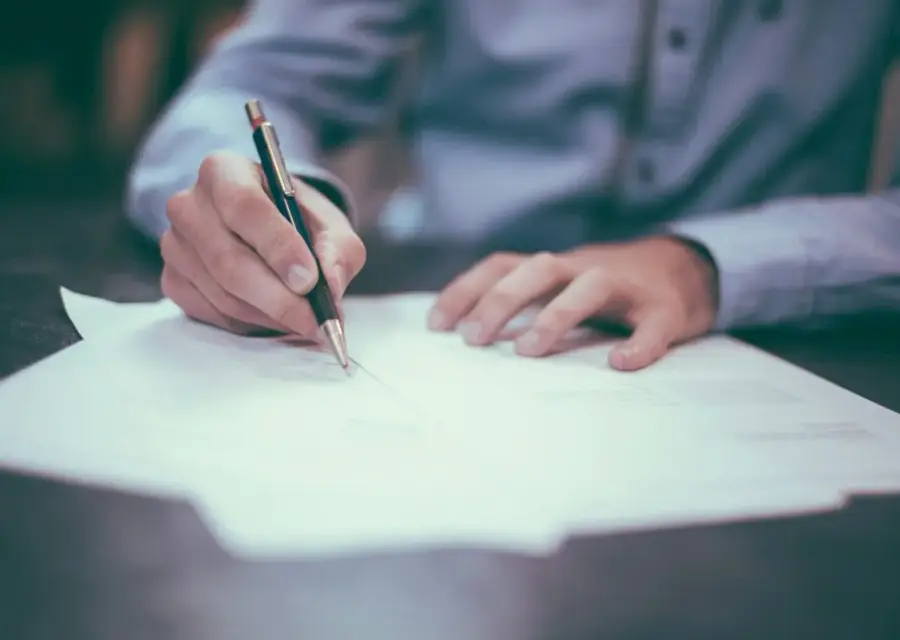 Documenti e penna su una scrivania, richiamo all’iscrizione professionale
